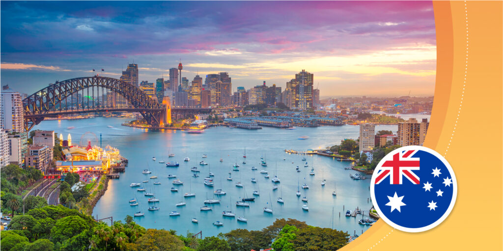 Une vue sur la mer d’une ville australienne ; un pont incurvé au-dessus d'une baie bleue et un horizon du centre-ville avec de hautes tours.