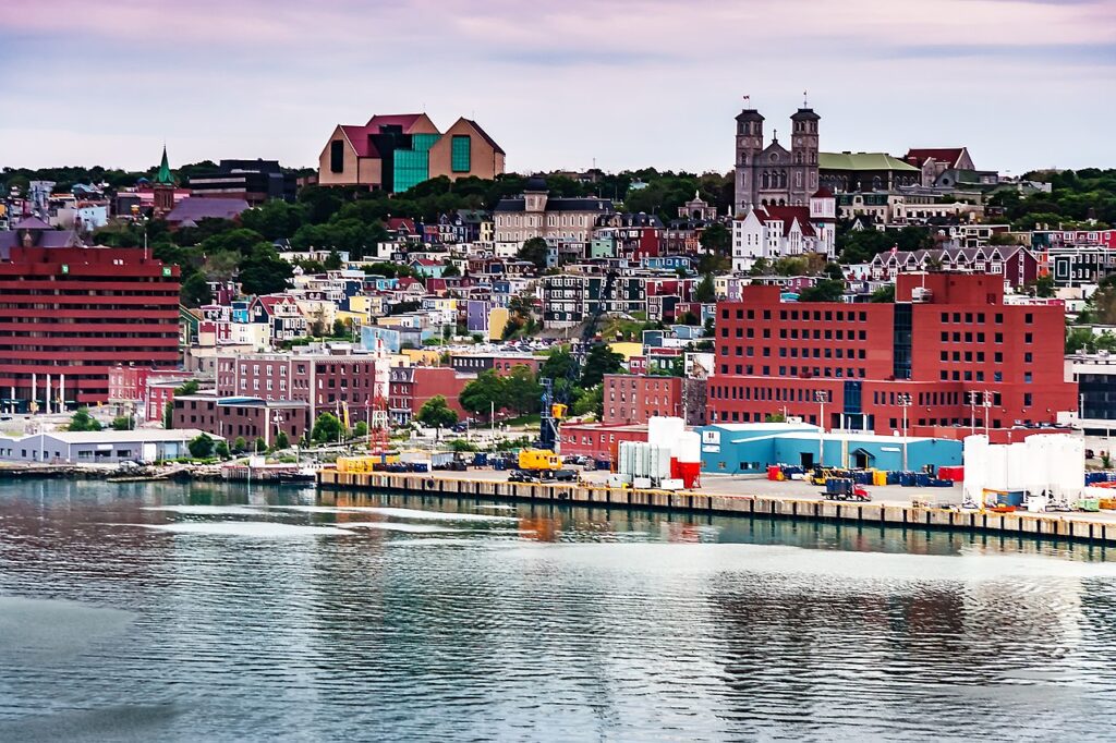 Une vue de St. John's depuis le port : des maisons colorées s'élèvent sur une colline en bord de mer
